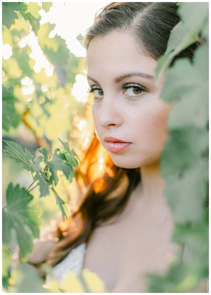 bride peeking through the grape leaves
