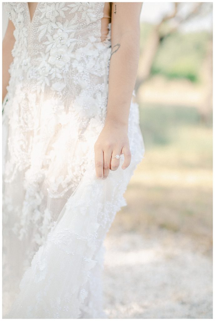 bride holding side of dress in the breeze