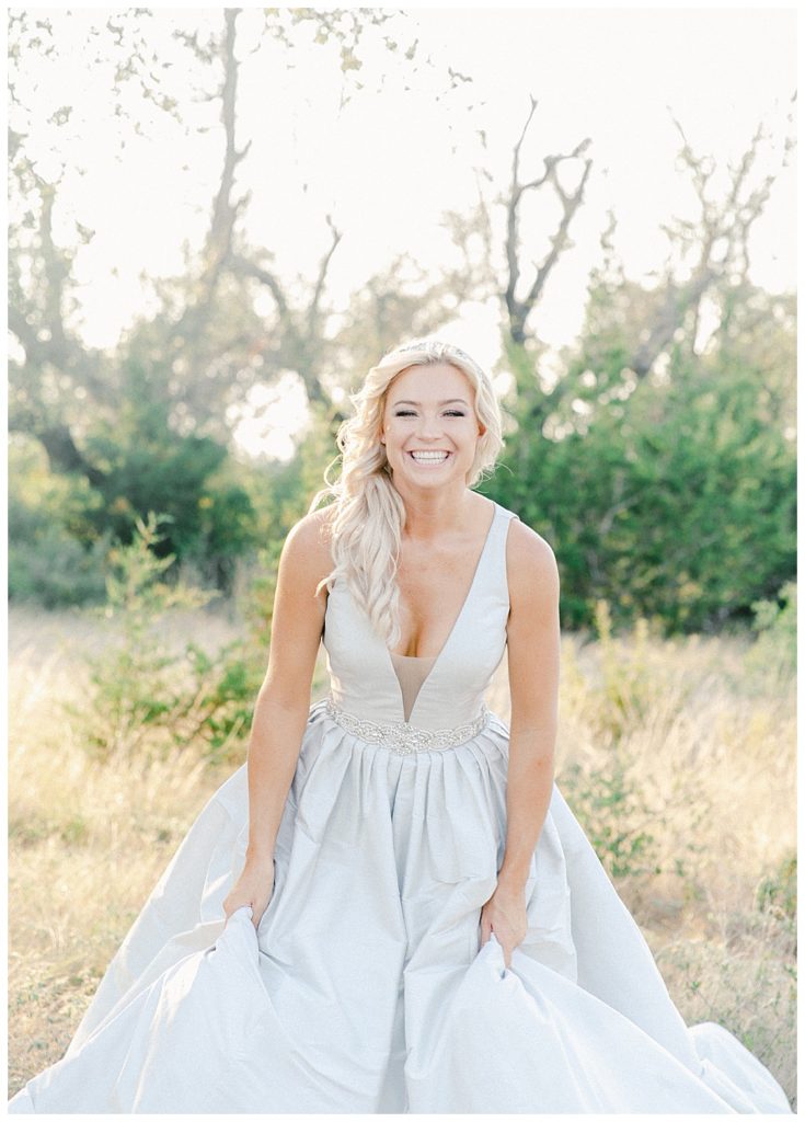 bride laughing while holding her dress