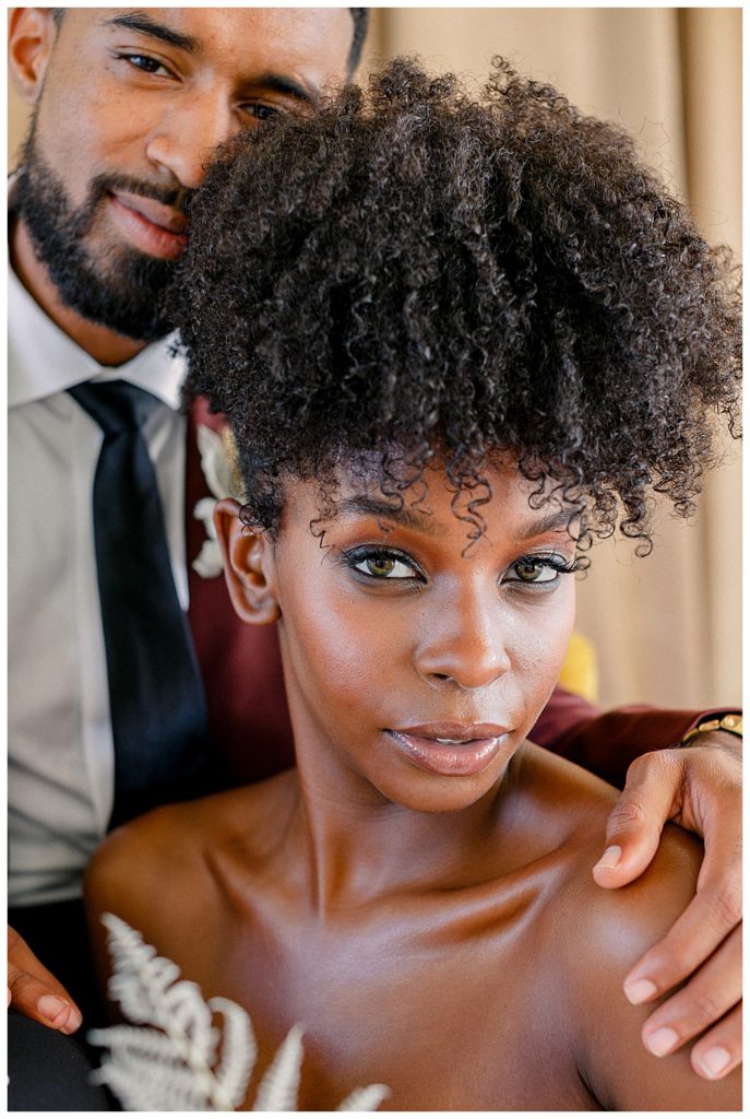 African American groom leaning on his bride with natural hair
