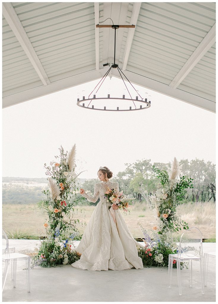 bride in front of modern elegant altar flowers