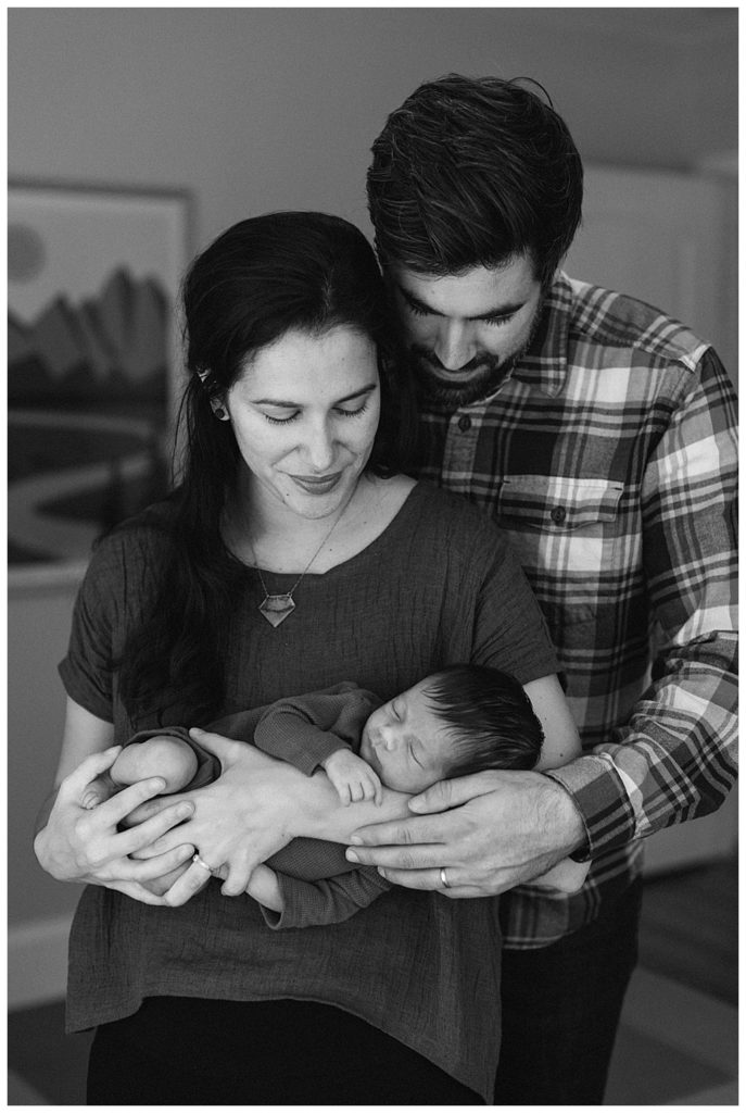 black and white photo of new parents cradling newborn daughter