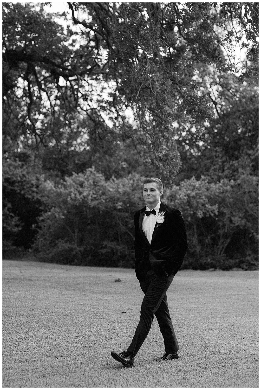 groom walking in black and white