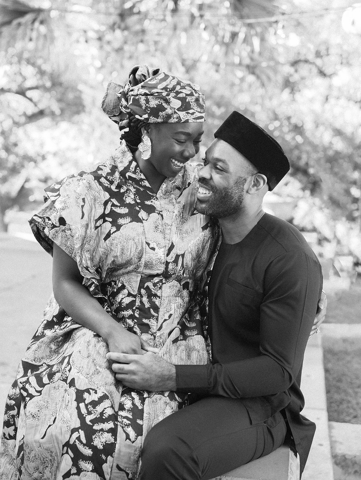 A woman sits on the lap of her fiance for their Austin engagement photos.