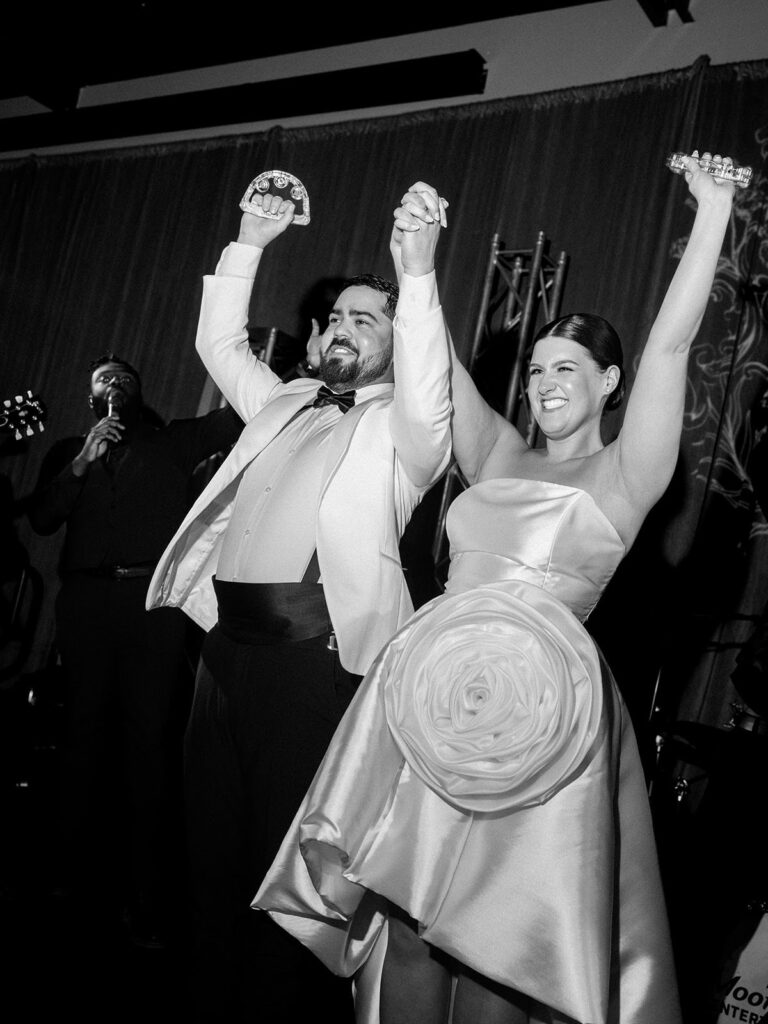 A couple holds hands above their head in celebration to show how relaxed a good photography timeline for weddings can make you.