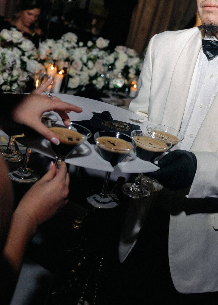 A caterer passes espresso martinis on a tray to wedding guests at a Witte Museum wedding.