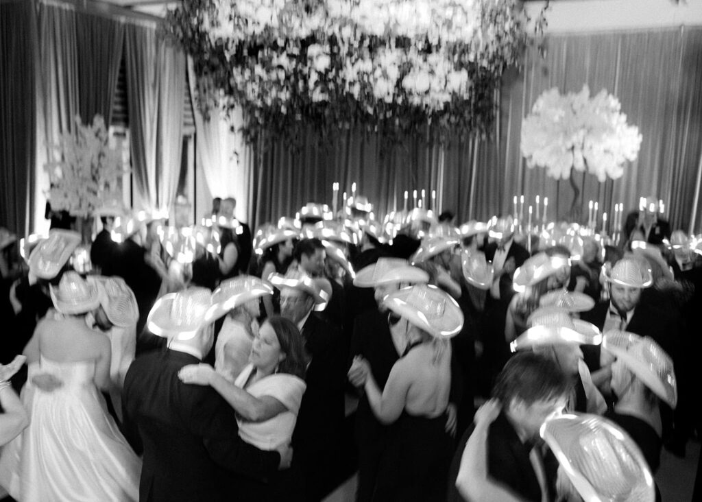 The dance floor is filled with people wearing light-up cowboy hats at a Witte Museum wedding.