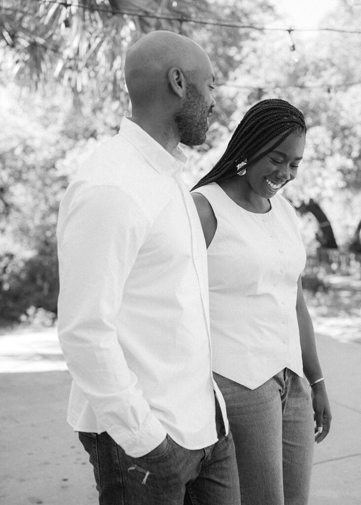 A couple walks together holding hands for their Austin engagement photos.