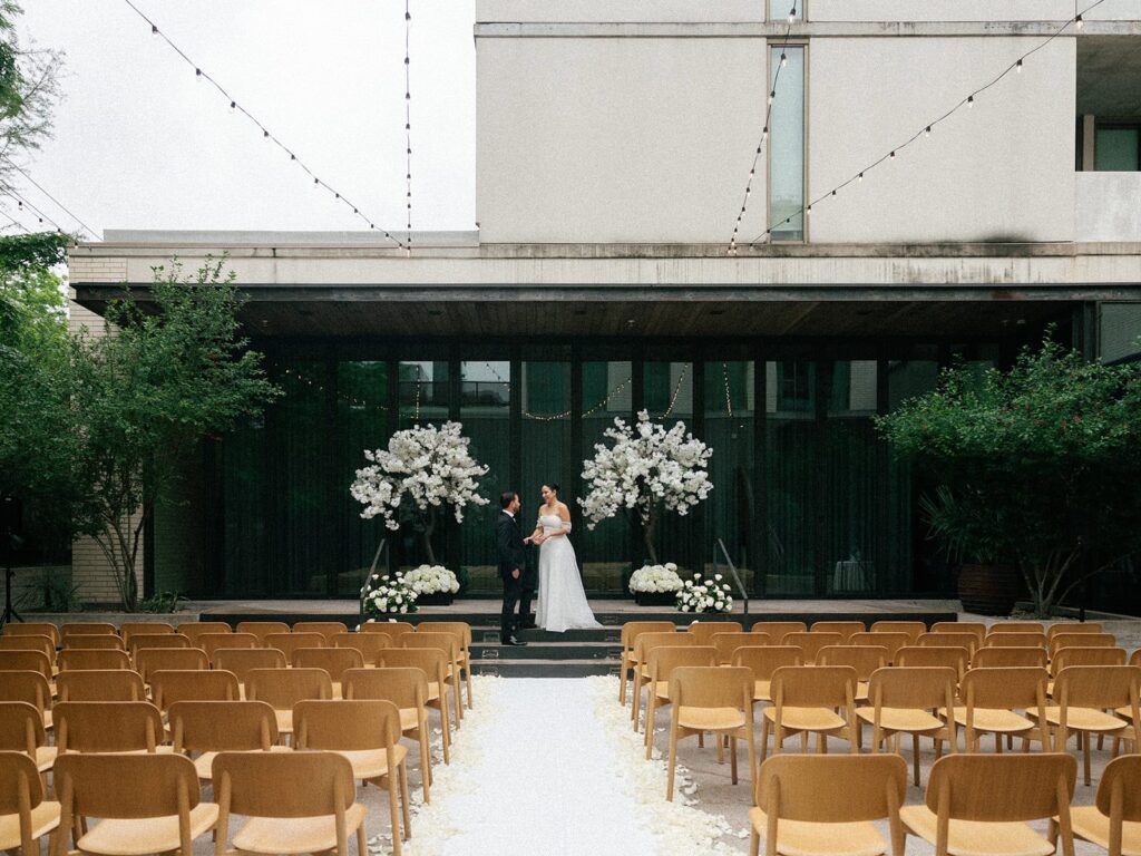 A bride and groom pose together at the altar of their South Congress Hotel wedding.