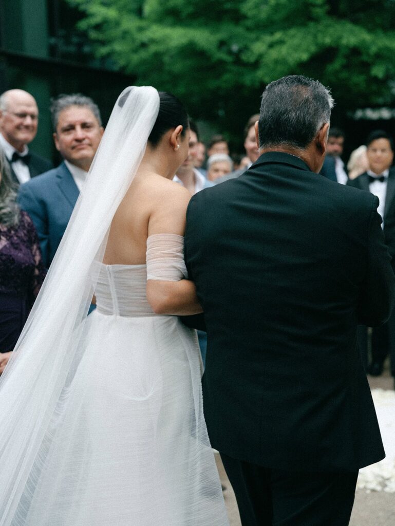 The bride and her father walk down the aisle to her South Congress Hotel wedding.