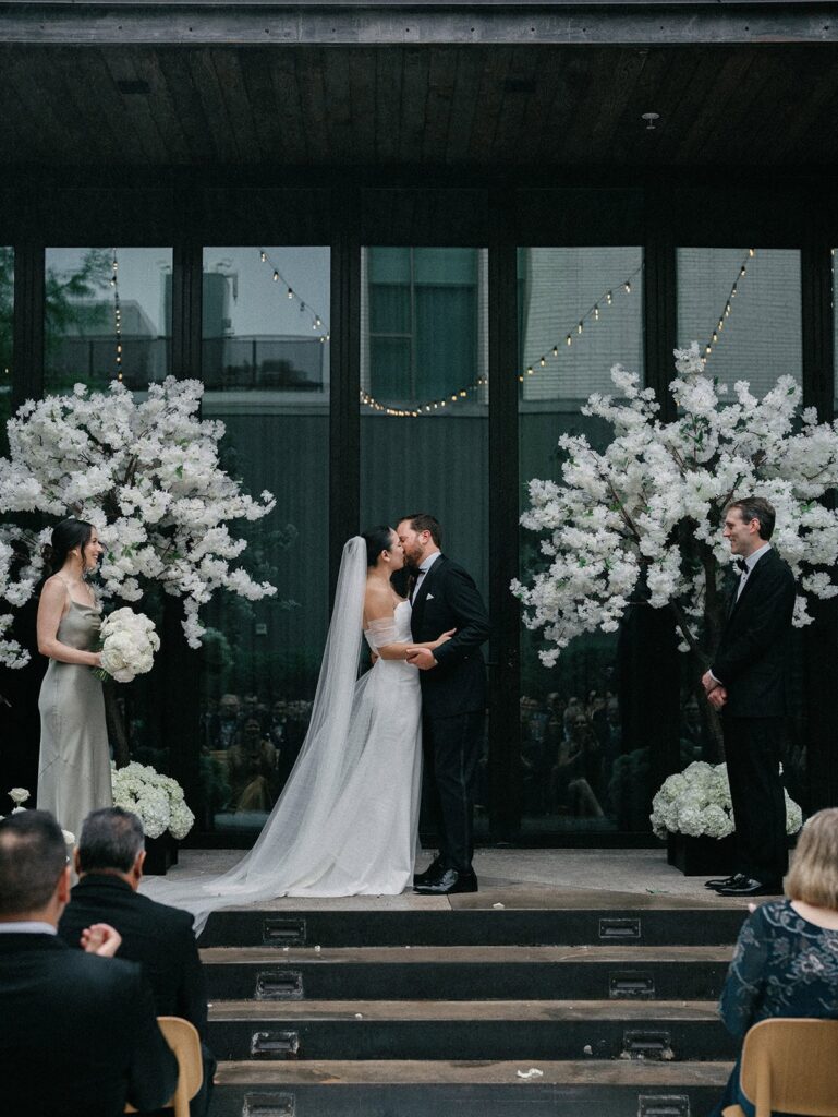 A bride and groom kiss at the altar of their South Congress Hotel wedding.