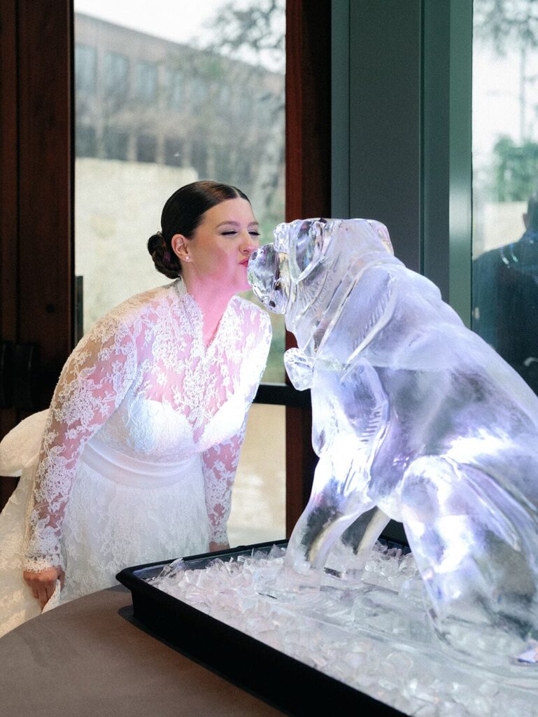 The bride kisses an ice statue of her dog at her Witte Museum wedding reception.